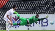 Al Rayyan goalkeeper Oumar Barry tries to stop the ball from entering the net during their AFC Champions League match against Saudi Arabia's Al Hilal at the Jassim Bin Hamad Stadium in Doha .