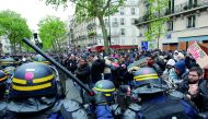 French riot police face off with demonstrators the day after the country went to the polls, in Paris, yesterday. Police arrested 141 people in eastern Paris in clashes with masked protesters after the election of pro-business independent Emmanuel Macron a