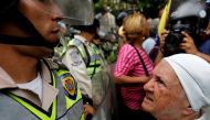 A nun (R) confronts riot security forces while rallying against President Nicolas Maduro in Caracas, Venezuela, May 12, 2017. REUTERS/Carlos Garcia Rawlins
