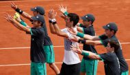 Serbia's Novak Djokovic celebrates winning his first round match against Spain's Marcel Granollers with ball boy. (Reuters / Gonzalo Fuentes)