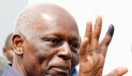 FILE PHOTO: Angola's President Jose Eduardo dos Santos shows off his inked finger to photographers after casting his vote during national elections in the capital Luanda, August 31, 2012. REUTERS/Siphiwe Sibeko/File Photo.