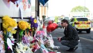 Well wishers look at messages of support and floral tributes to the victims of the Manchester attack,outside the Manchester Arena Complex in Manchester on May 27, 2017.   AFP / Oli SCARFF
