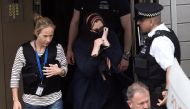 Police officers escort a woman to a police van after raiding a block of flats in Barking, east London, Britain, June 4, 2017. REUTERS/Hannah McKay
