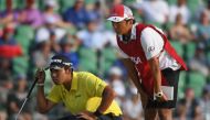 Hideki Matsuyama of Japan and caddie Daisuke Shindo lines up a putt on the 18th green during the second round of the 2017 U.S. Open at Erin Hills on June 16, 2017 in Hartford, Wisconsin. Ross Kinnaird/AFP

