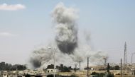 Smoke billows from buildings in the northern Syrian city of Raqa on June 18, 2017, during an offensive by US-backed fighters to retake the Islamic State (IS) group bastion. / AFP / DELIL SOULEIMAN