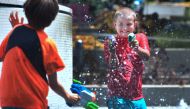 Boys cool of with water guns at the Grand Park splash pad in downtown Los Angeles, California on June 19, 2017, amid a Southern California heatwave with highs again forecast to hit triple-digits in some Los Anegels County communities. / AFP / FREDERIC J. 