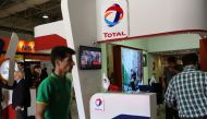 This file photo taken on May 06, 2015 shows people walking past the stand of French oil and gas company Total during Iran's annual International Oil, Gas, Refining & Petrochemical Exhibition in Tehran. (AFP / ATTA KENARE)