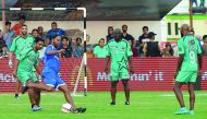 Former FC Barcelona player, Brazilian Ronaldinho (third left) kicks the ball watched by Pakistani football players during a friendly match in Lahore yesterday. 