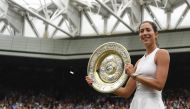 Spain's Garbine Muguruza holds up The Venus Rosewater Dish as she celebrates beating US player Venus Williams to win the women's singles final on the twelfth day of the 2017 Wimbledon Championships at The All England Lawn Tennis Club in Wimbledon, southwe