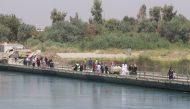 Iraqis walk towards the floating bridge between east and west of Mosul, Iraq, July 21, 2017. Picture taken July 21, 2017. (REUTERS/Khalid Al-Mousily)