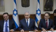 Israeli Prime Minister Benjamin Netanyahu (C), flanked by Government Secretary Tzachi Braverman (R) and Minister of Transportation Israel Katz, attends the weekly cabinet meeting at his office in Jerusalem on July 23, 2017. AFP / Abir Sultan


