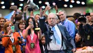 Warren Buffett tossing a newspaper at the Berkshire Hathaway annual shareholders meeting in Omaha in 2015 
