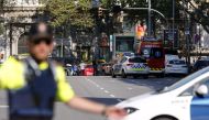 A policemen stand as he blocks the street to a cordoned off area after a van ploughed into the crowd, injuring several persons on the Rambla in Barcelona on August 17, 2017. / AFP / PAU BARRENA