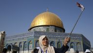 A Palestinian girl from the Gaza Strip takes a selfie outside the Dome of the Rock mosque in the Al-Aqsa mosque compound in Jerusalem's old city on August 20, 2017 as he visits the city for the first time as part of an exchange programme run by the UN age