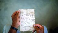 Soltan displays a message that was written by Bethany Wright and her boyfriend Zac Marriner, after he found it in a bottle off a Gaza beach.