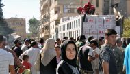 Local residents gather to receive humanitarian aid parcels provided by the Syrian Red Crescent in the northeastern city of Deir Ezzor on September 9, 2017. / AFP / STRINGER
