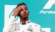 Mercedes' Lewis Hamilton wipes his forehead on the podium. REUTERS/Edgar Su
