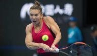 Simona Halep of Romania hits a return during her women's singles match against Maria Sharapova of Russia at the China Open tennis tournament in Beijing on October 4, 2017. / AFP / NICOLAS ASFOURI
