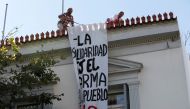Employees of the Spanish embassy remove a banner hung by self-proclaimed anarchists in favor of Catalonian independence, seen at the facade of the Spanish embassy in Athens, Greece, October 11, 2017. The banner reads 