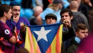 A fan holds up the Catalan pro-independence 'Estelada' flag before kick off of the English Premier League football match between Manchester City and Stoke City at the Etihad Stadium in Manchester, north west England, on October 14, 2017. (AFP / Oli SCARFF