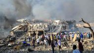 Men and Somalian soldiers arrive on the site to rescue victims of the explosion of a truck bomb in the centre of Mogadishu, on October 14, 2017.   AFP / Mohamed ABDIWAHAB
