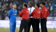 Australia's captain David Warner (L) speaks with match referee Richie Richardson and all the umpires as play is delayed due to wet outfield on the third and final T20 cricket match in a series between India-Australia at the Rajiv Gandhi International Cric