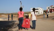 Children hold hands of a little girl wearing a Turkish flag during Turkish Army's armoured vehicles' deployment to the border line in the Turkish border district of Reyhanli near Syria's Idlib, within the reconnaissance activities in Idlib as part of an i