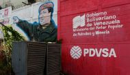 FILE PHOTO: The logo of the Venezuelan state oil company PDVSA is seen next to a mural depicting Venezuela's late President Hugo Chavez at a gas station in Caracas, Venezuela March 2, 2017. Reuters/Carlos Garcia Rawlins