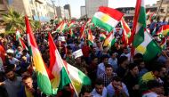 Iraqi Kurds wave flags of Iraqi Kurdistan and shout slogans during a demonstration outside the UN Office in Arbil, the capital of the autonomous region, on October 21, 2017, protesting against the escalating crisis with Baghdad. / AFP / SAFIN HAMED
