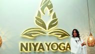 Jawaher Al Fardan poses before the Niya Yoga logo at its studio in Doha.  Niya Yoga is holding a number of ladies-only events that will raise funds for the Breast Cancer Awareness Association in Qatar.