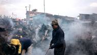 Residents walk amid the remains of market stalls that were burnt to the ground during protests relating to the presidential election in the Kamangware district of Nairobi on October 28, 2017. AFP / Marco LONGARI