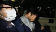 (FILES) This file photo taken on November 1, 2017 shows suspect Takahiro Shiraishi (C) covering his face with his hands as he is transported to the prosecutor's office from a police station in Tokyo. AFP / JIJI PRESS / STR 