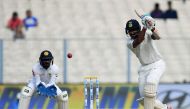 India's Cheteshwar Pujara (R) plays a shot as Sri Lanka's wicket-keeper Niroshan Dickwella looks on during the third day of the first Test between India and Sri Lanka at the Eden Gardens cricket stadium in Kolkata on November 18, 2017. GETTYOUT / AFP / Di