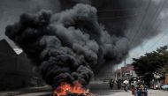 Motorcyclists pass a burning tyre barricade following a demonstration by Kenyan opposition party National Super Alliance (NASA) supporters on November 17, 2017 in Nairobi.