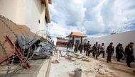 A photo of Police inspecting the exterior of an immigration detention centre, from where 20 ethnic Uighurs escaped on Monday morning, in Sadao district in the southern Thai province of Songkhla on November 21, 2017. / AFP / TUWAEDANIYA MERINGING
