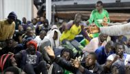 Migrants wait to receive food as they sit at Tripoli port after they were recuse by Libyan coast guards, in Tripoli, Libya December 13, 2017.  REUTERS/Hani Amara
