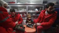Syrian staff from the International Committee of the Red Cross take part in an evacuation operation in Douma in the eastern Ghouta region on the outskirts of the capital Damascus on December 26, 2017.  AFP / ABDULMONAM EASSA