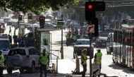 A white SUV (L) sits in the middle of the road as police and emergency personnel work at the scene of where a car ran over pedestrians in Flinders Street in Melbourne on December 21, 2017. / AFP.
