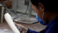 FILE PHOTO: A man checks a tusk at an ivory workshop in Beijing, China, March 31, 2017. REUTERS/Thomas Peter/File Photo.