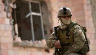 A member of the Tunisian special forces stands guard outside a house containing the body of a man after security forces said they killed a 