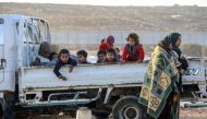 Syrian children are seen on the back of a truck as two old women stand by it in Idlib, Syria on January 09, 2018.  Muhammed Abdullah - Anadolu
