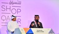 Hamad Al Khaja of QTA (right) announces one of the lucky winners of the second weekly raffle draw held at Hyatt Plaza Mall on Thursday.