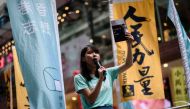 A file photo of pro-democracy Demosisto party member Agnes chow speaking to passing pedestrians in Hong Kong ahead of a candlelight vigil to mark the 28th anniversary of the June 4 Tiananmen crackdown in Beijing in 1989, June 4, 2017. / AFP / Anthony WALL
