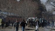 Afghan volunteers and policemen carry injured men on an ambulance at the scene of a car bomb exploded in front of the old Ministry of Interior building in Kabul on January 27, 2018.   AFP / WAKIL KOHSAR
