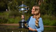 Denmark's Caroline wozniacki holds up the trophy during a photocall at the Royal Botanical Gardens in Melbourne on January 28, 2018, a day after beating Romania's Simona Halep in their women's singles final match at the Australian Open tennis tournament. 