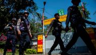 Police officers patrol in front of the residence of Myanmar's leader Aung San Suu Kyi in Yangon on February 1, 2018, after a petrol bomb was hurled into the compound. AFP / YE AUNG THU
