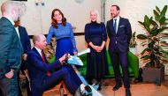 Britain's Prince William, Duke of Cambridge, rides on an apparatus while Britain's Catherine, Duchess of Cambridge, Norway's Crown Princess Mette-Marit and Norway's Crown Prince Haakon react during a visit at MESH, the Nordic Creators’ Community in Oslo, 