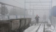 FILE PHOTO: A coal worker walks next to wagons amid smog in Huaibei, Anhui province, China January 29, 2018. REUTERS/Stringer/File Photo