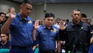 File photo of Philippines National Police (PNP) officers Jeremias Pereda, Jerwin Cruz and Arnel Oares take an oath during a hearing on the killing of 17-year-old high school student Kian Delos Santos in a police raid, at the Senate headquarters in Pasay c