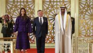 A handout picture released by the Jordanian Royal Palace on February 7, 2018 shows Jordanian King Abdullah II (C) and Queen Rania of Jordan (L) being received by Abu Dhabi Crown Prince Mohammed bin Zayed Al-Nahyan (R) in the capital Abu Dhabi. AFP Photo /